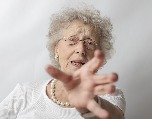 Alte Frau mit grauem Haar, das sich weigert, ein Foto zu machen