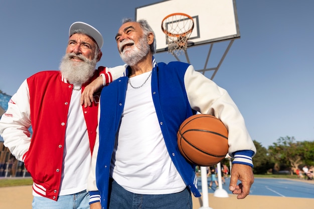 Kostenloses Foto alte männer, die draußen college-jacke tragen