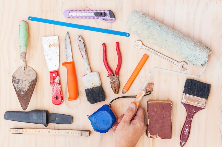 Kostenlose Foto alter bauhandwerkzeugsatz mit arbeitskraft überreichen weißen hölzernen hintergrund