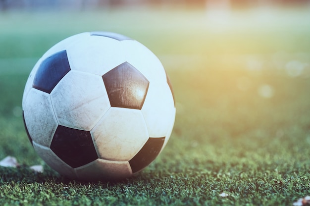 Alter Fußball in der grünen künstlichen Rasenfläche - Fußball oder Fußballsportspielwettbewerb