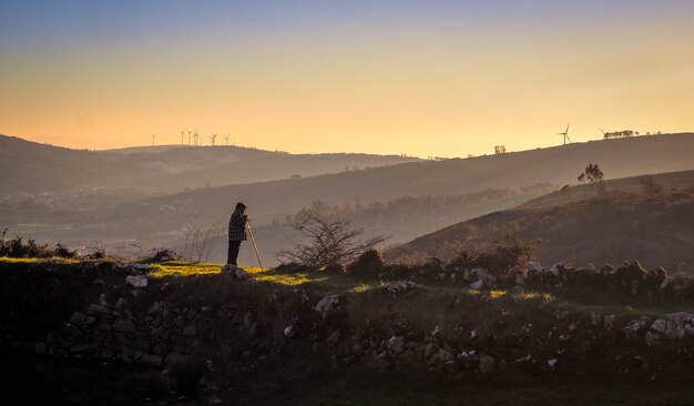 Alter Hirte, der zu den Bergen bei Sonnenuntergang schaut