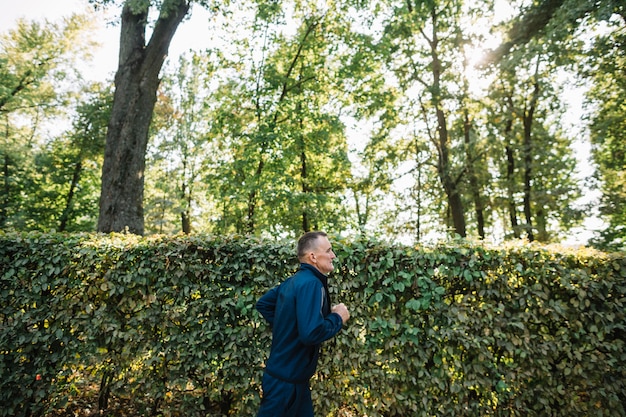 Kostenloses Foto alter mann, der draußen in sommerzeit läuft