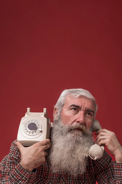 Kostenloses Foto alter mann, der ein telefon hält