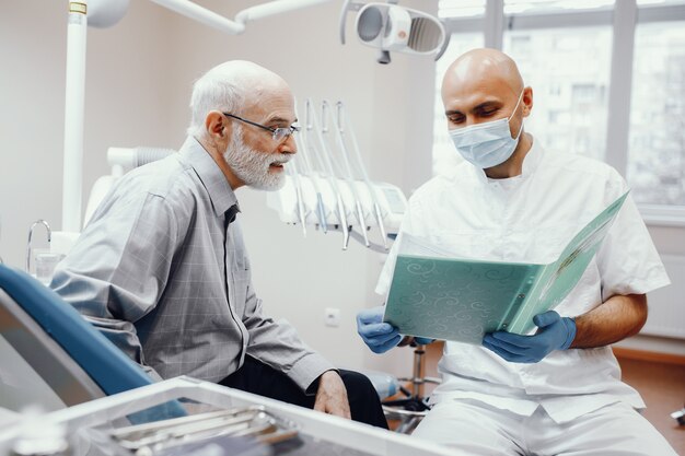 Alter Mann, der im Büro des Zahnarztes sitzt