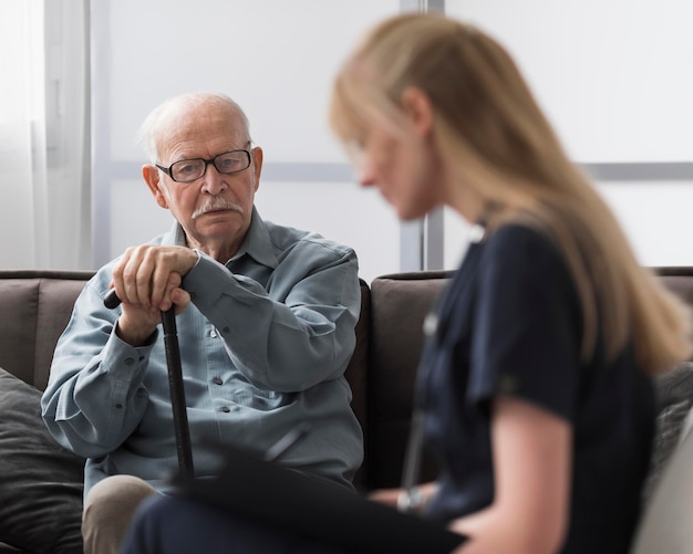 Alter Mann, der von Krankenschwester konsultiert wird