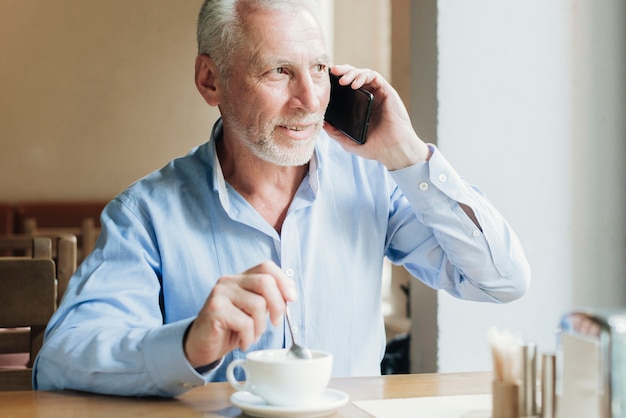 Alter Mann des mittleren Schusses, der am Telefon spricht