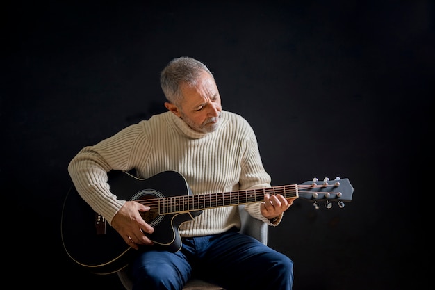 Alter Mann des mittleren Schusses, der Gitarre spielt