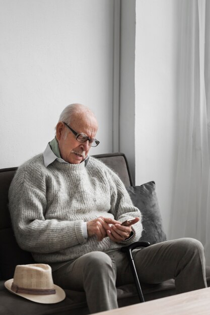 Alter Mann in einem Pflegeheim mit Smartphone