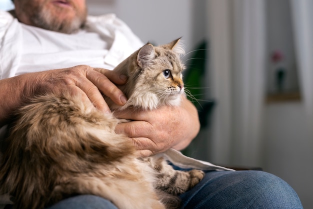 Kostenloses Foto alter mann streichelt katze seitenansicht