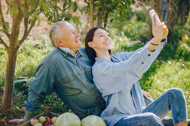 Alter Senior, der in einem Sommergarten mit Ernte steht