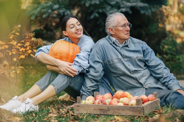 Alter Senior in einem Sommergarten mit Enkelin