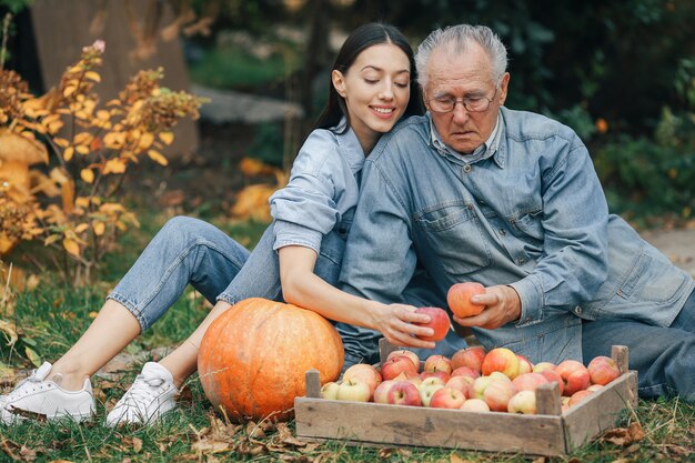 Alter Senior in einem Sommergarten mit Enkelin