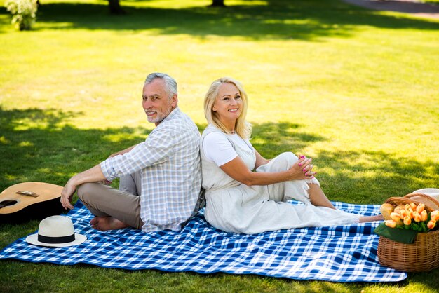 Altes Ehepaar auf einer Decke in die Kamera schaut