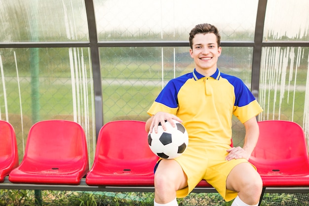 Amateurfußballkonzept mit Mann auf Bank