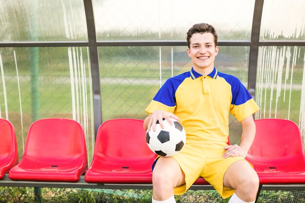 Amateurfußballkonzept mit Mann auf Bank