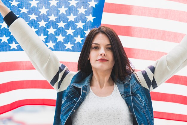 Amerikanische Flagge und Frau mit den Händen oben