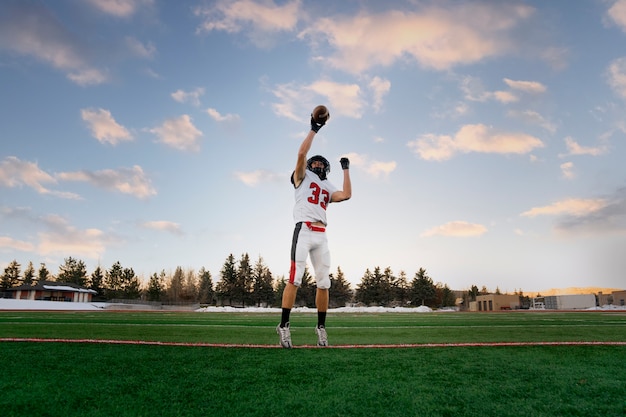 Kostenloses Foto amerikanischer männlicher fußballspieler in uniform auf dem feld