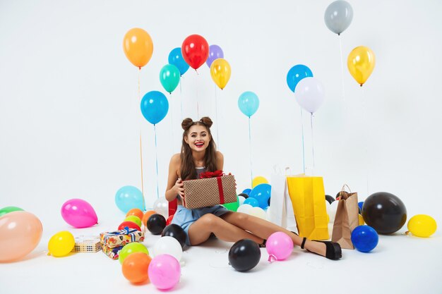 Amuzed Teen Girl nach der Geburtstagsfeier. Hält eine riesige Geschenkbox