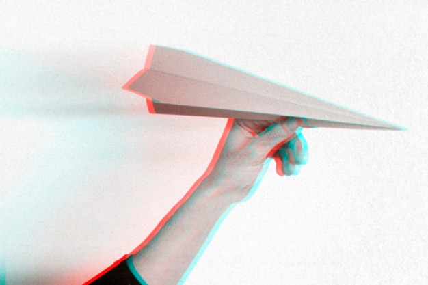 Kostenloses Foto anaglypheneffekt auf der hand, die papierflugzeug hält