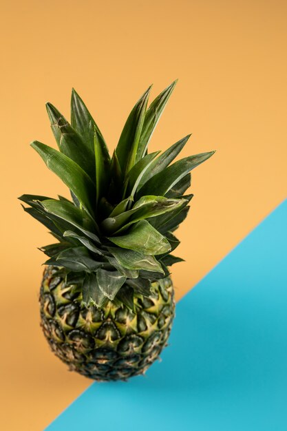 Ananas auf einer orange blauen Farbwand, Draufsicht