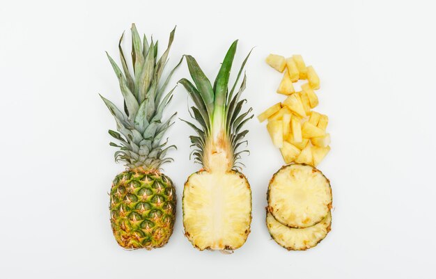 Ananas ganz, halb und Scheiben Draufsicht auf einem Weiß