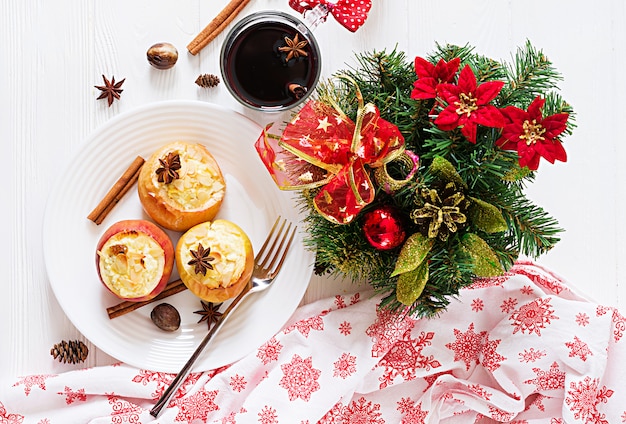Angefüllte Bratäpfel mit Hüttenkäse, Rosinen und Mandeln für Weihnachten auf einer weißen Tabelle. Weihnachtsessen Dessert.