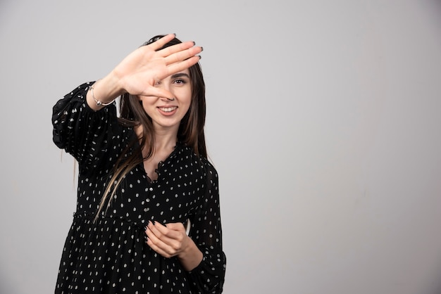 Angenehm aussehende junge Brunettefrau, die steht und aufwirft.