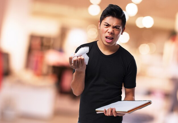 Angry man ein Blatt aus einem Notebook-Ripping