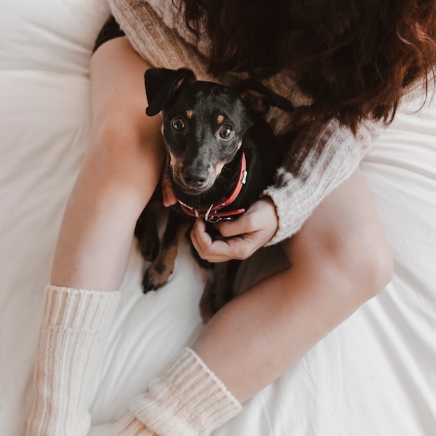 Anonyme Frau mit Hund auf Bett