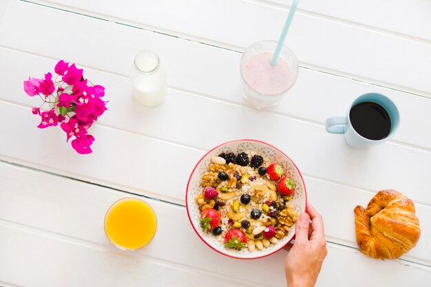 Anonyme Person serviert Müsli mit Kaffee