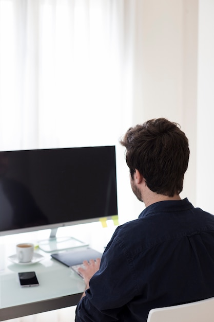 Anonymer Mann, der Computer im Büro verwendet