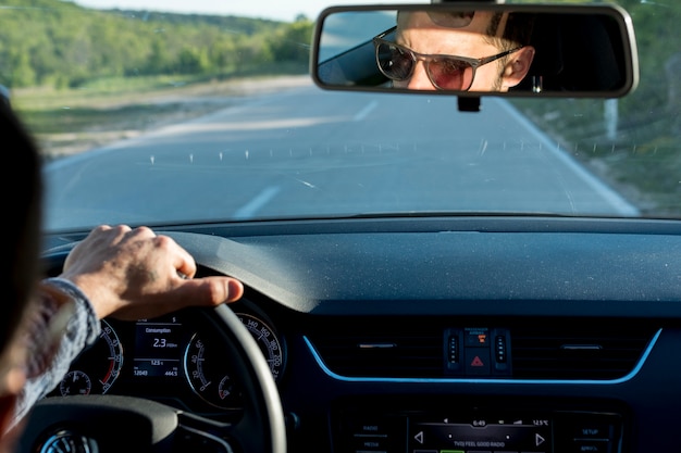 Anonymer Mann, der mit Auto am sonnigen Tag reist