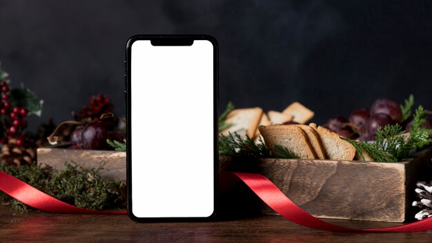 Anordnung des Weihnachtsessens mit leerem Smartphone