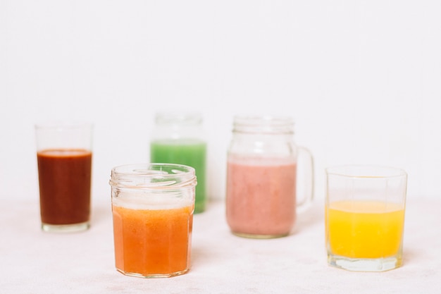 Anordnung für bunte Smoothies mit weißem Hintergrund