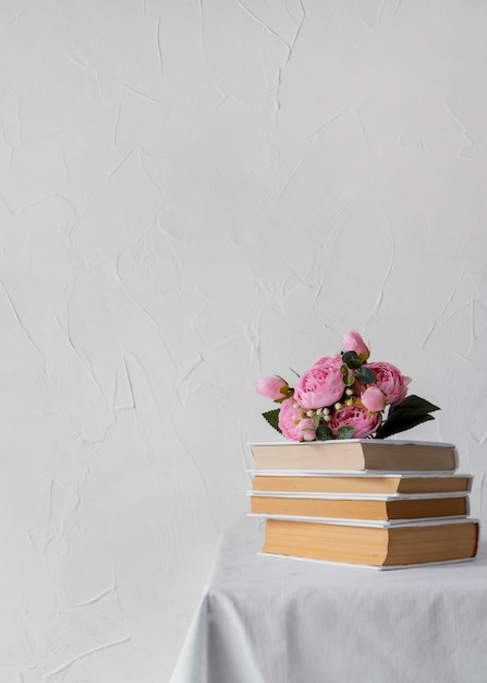 Kostenloses Foto anordnung mit bücherstapel und blumen