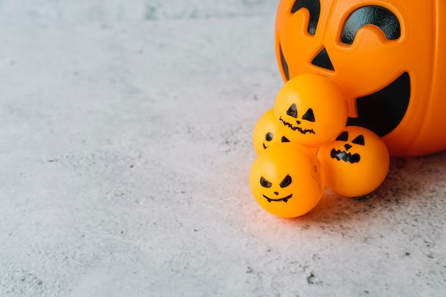 Anordnung mit Halloween-Korb und kleinem Ball mit furchtsamen Gesichtern