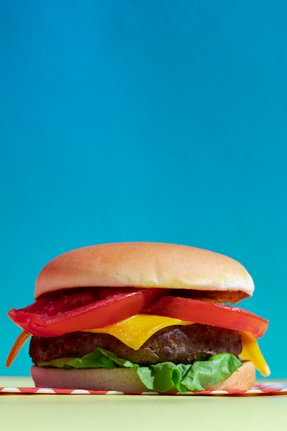 Anordnung mit köstlichem Cheeseburger und blauem Hintergrund