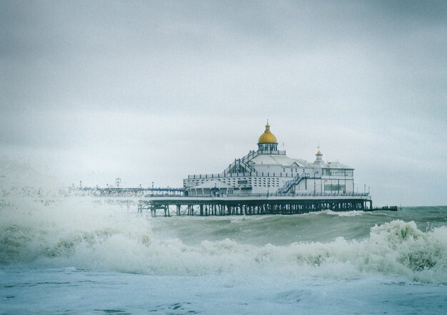 Ansicht des Eastbourne Pier in England mit starken Wellen im Ozean