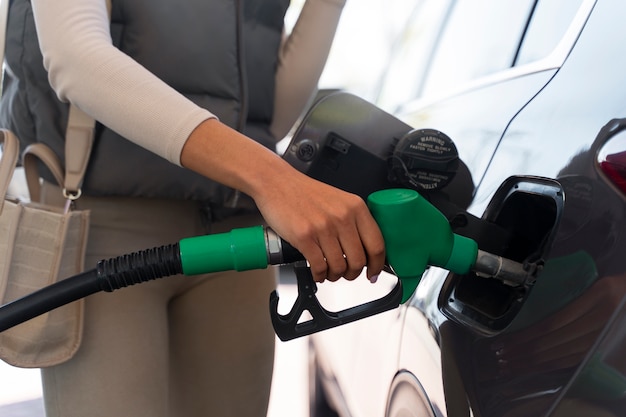 Ansicht einer Frau mit Auto an der Tankstelle