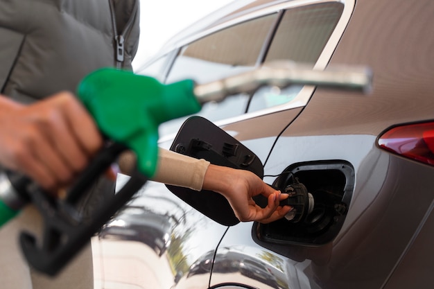 Ansicht einer Frau mit Auto an der Tankstelle