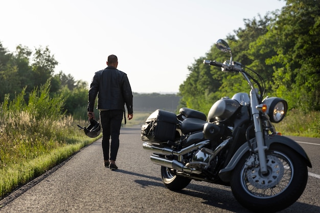 Kostenloses Foto ansicht einer person neben einem motorrad im freien