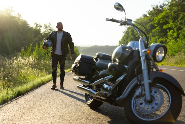 Kostenloses Foto ansicht einer person neben einem motorrad im freien