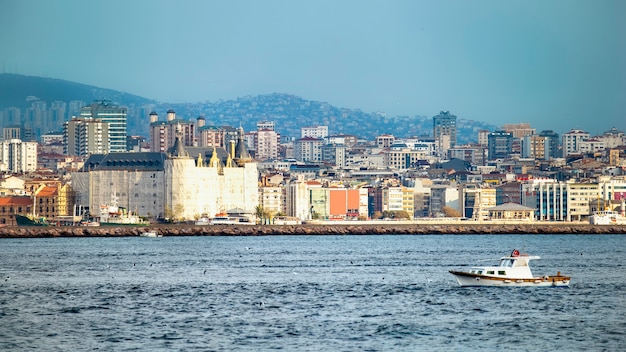 Ansicht eines Bezirks mit Wohngebäuden und hochmodernen Gebäuden in Istanbul, Bosporus-Straße mit beweglichem Boot auf dem Vordergrund, Türkei