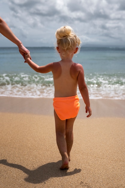 Kostenloses Foto ansicht eines jungen mädchens mit sonnenbrandhaut am strand