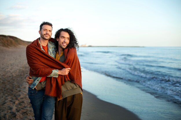 Ansicht eines schwulen Paares, das liebevoll ist und Zeit zusammen am Strand verbringt