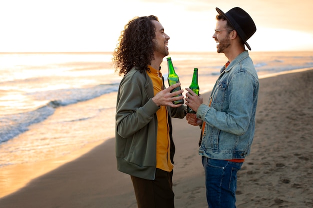 Kostenloses Foto ansicht eines schwulen paares, das liebevoll ist und zeit zusammen am strand verbringt