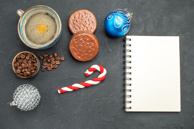 Ansicht von oben eine Tasse Kaffeeschale mit Kaffeesamen Kekse Weihnachten Details ein Notizbuch auf dunklem, isoliertem Hintergrund