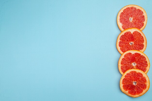 Ansicht von oben frische Grapefruits auf blauem Hintergrund gesäumt