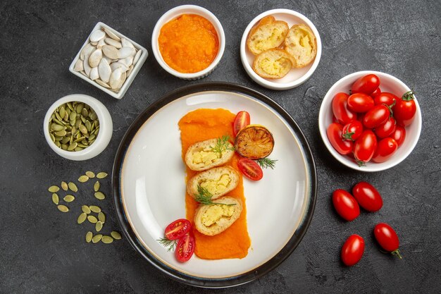 Ansicht von oben geschnittener Kartoffelkuchen mit frischen kleinen Tomaten auf dunkelgrauem Hintergrund