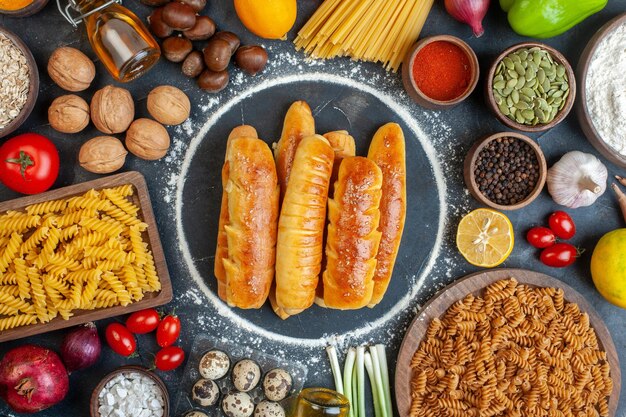 Ansicht von oben köstliche Bagels mit Nüssen, Eiern, Nudeln und Gewürzen auf dunklem Hintergrund Walnuss-Lebensmittelmahlzeitpfeffer-Frucht-Fotofarbe